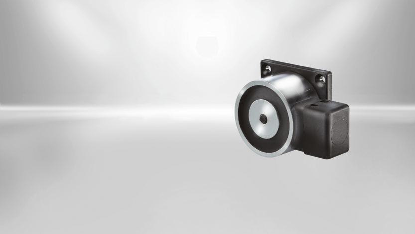 Door holding magnets from Kendrion are available in different designs. This type of STANDARD Line is staffed with a mounting plate and terminal clamp.